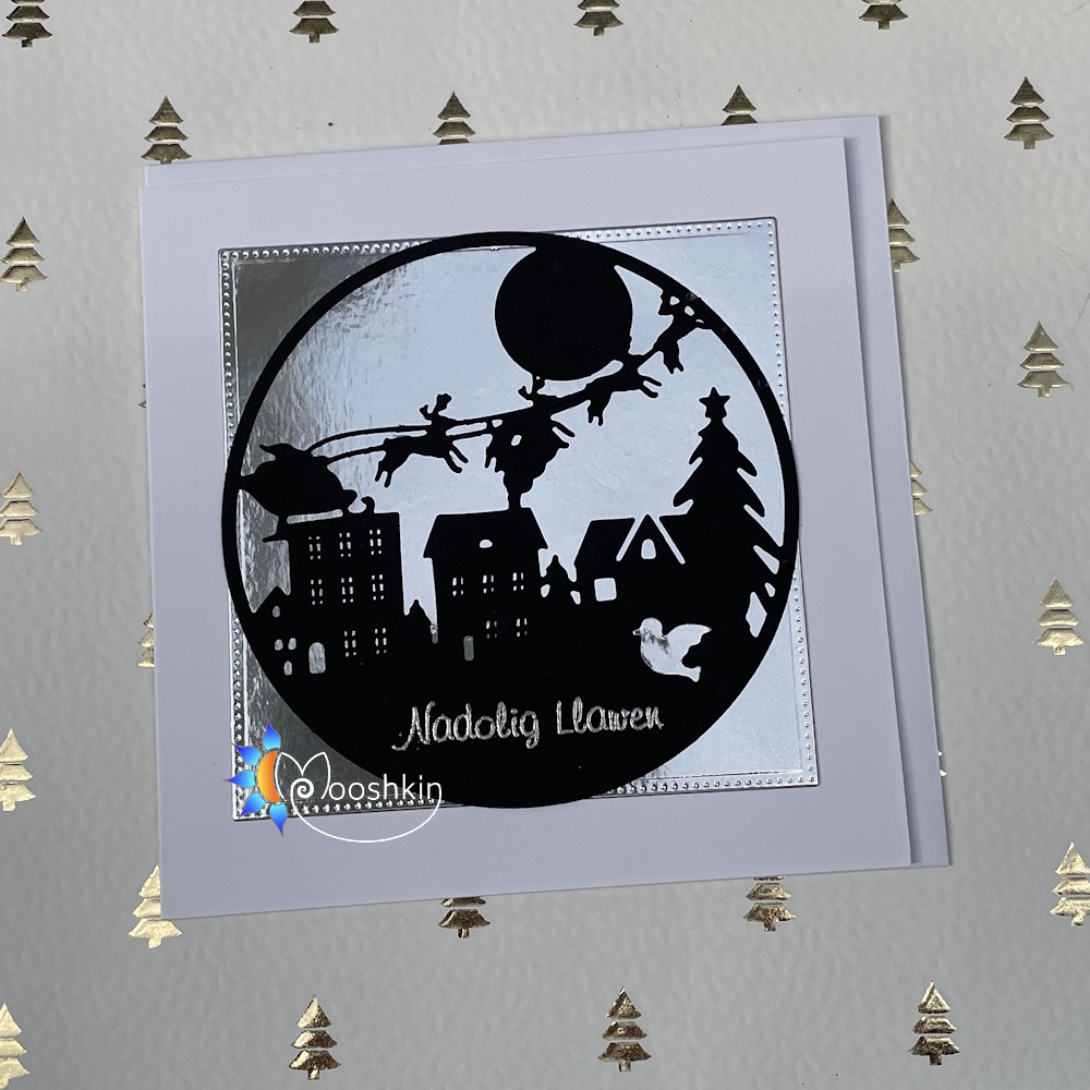Handmade Christmas card - silhouetted Santa, sleigh and town in black on a silver background
