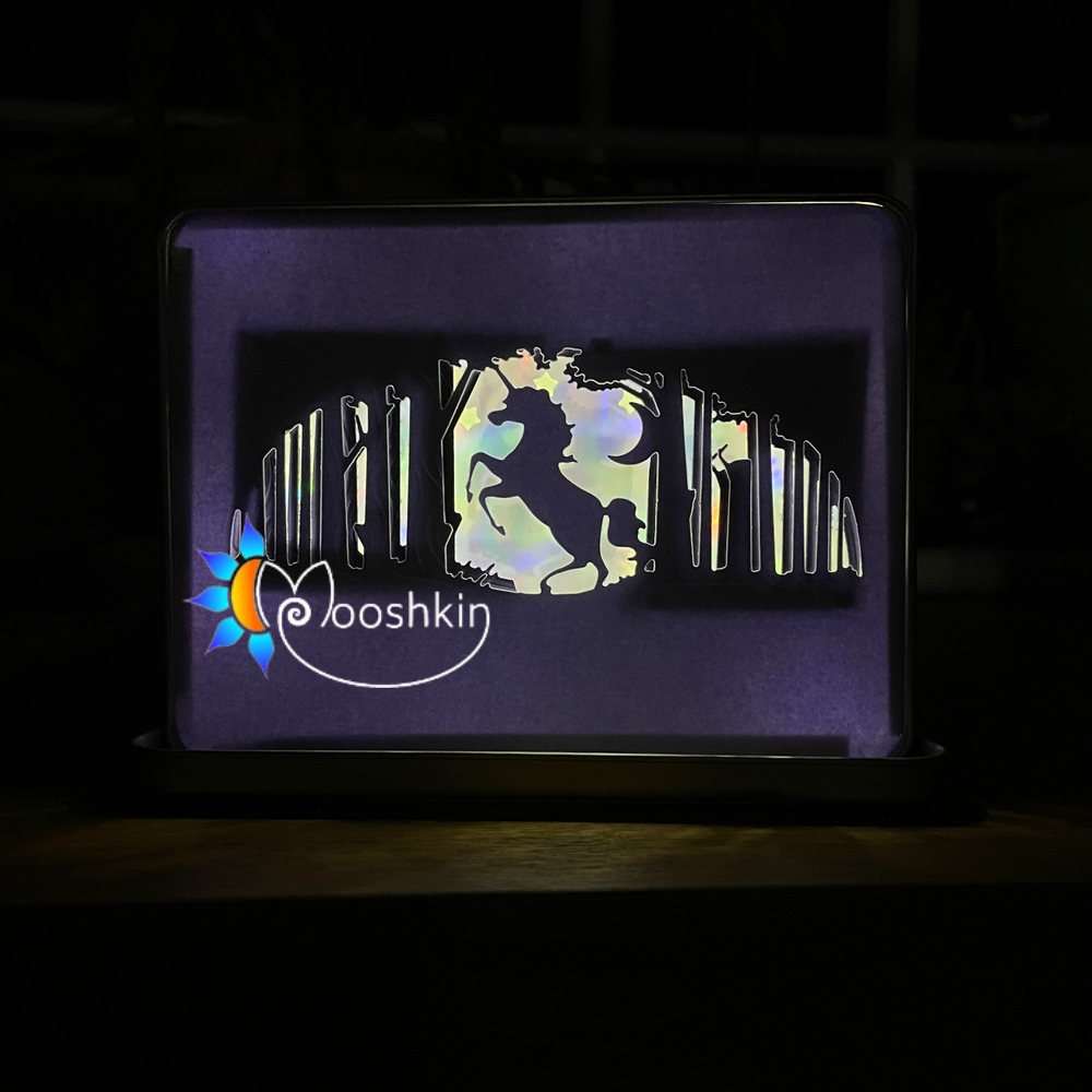 Lantin featuring a unicorn prancing in a forest, with a holographic rainbow mirror card background and warm white USB LEDs.