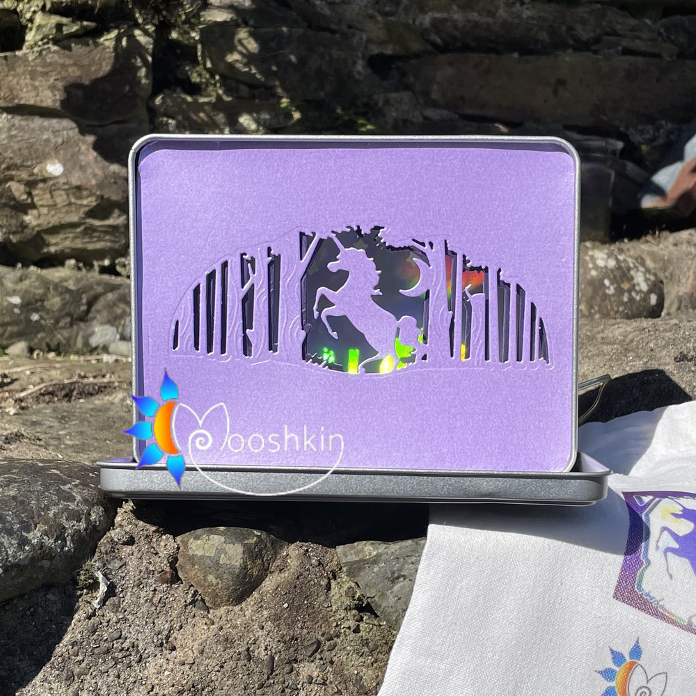 Lantin featuring a unicorn prancing in a forest, with a holographic rainbow mirror card background and warm white USB LEDs.