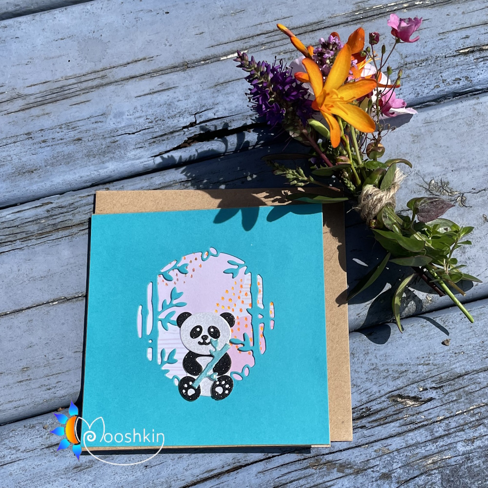Handmade greetings card featuring a die cut panda and bamboo forest