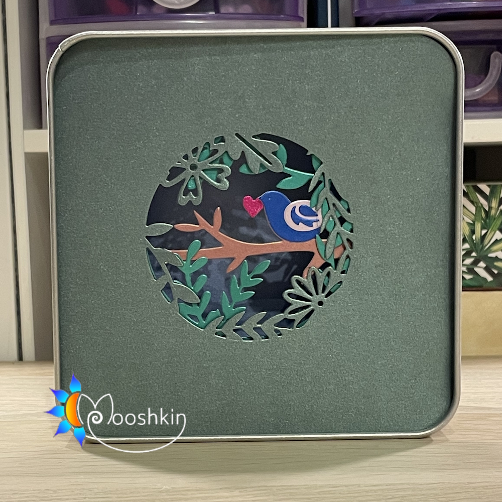 "Springtime is here" - a multi-coloured, multi-layered Lantin by Mooshkin - a light-up die-cut scene in a tin