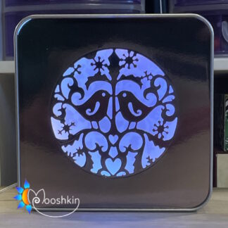 A Mooshkin Lantin featuring two turtle doves in a die-cut scene in a light-up tin
