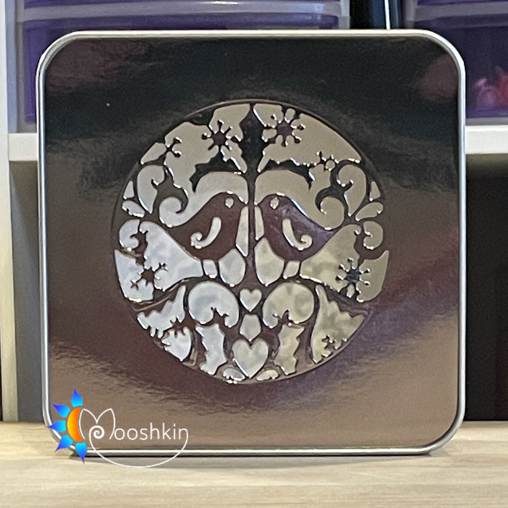 A Mooshkin Lantin featuring two turtle doves in a die-cut scene in a light-up tin