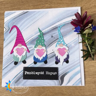 Handmade greetings card featuring three die-cut gnomes holding hearts, and the greeting 'penblwydd hapus' (Welsh for 'happy birthday')