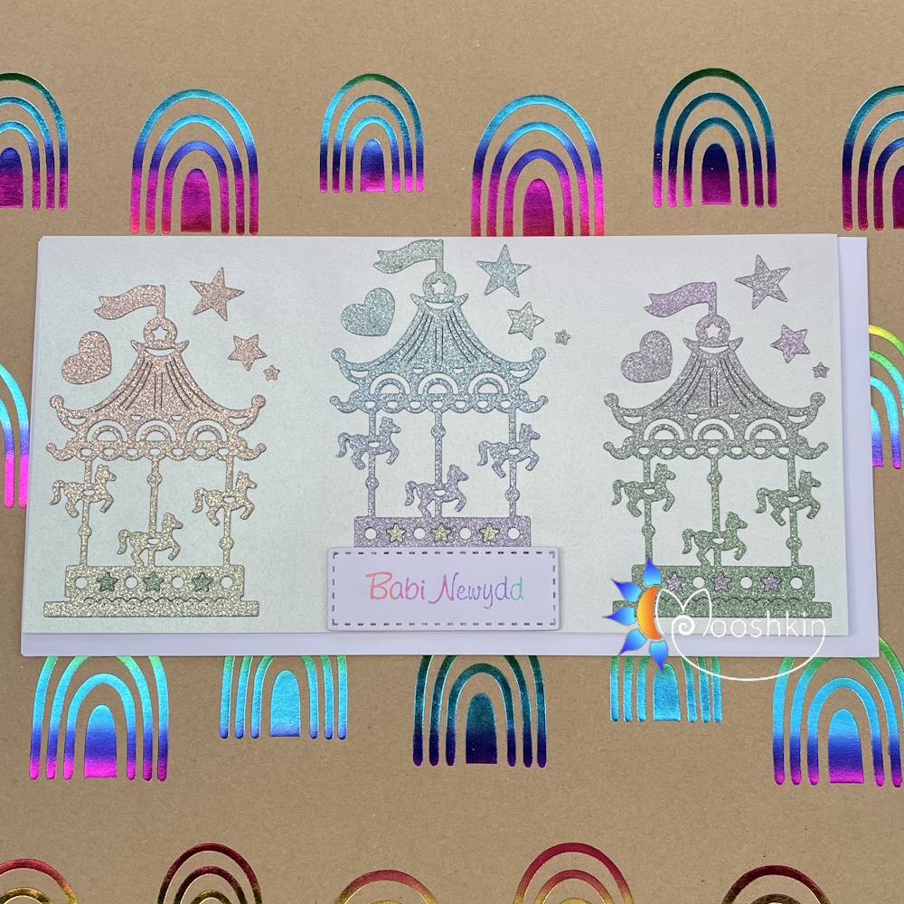 Handmade die cut greethings card featuring glittery carousels for a new baby