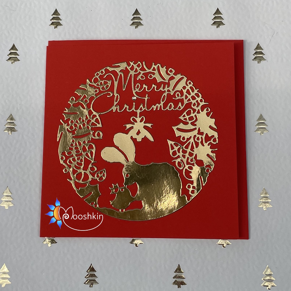 Handmade Christmas card: gold die cut of a rabbit and bird kissing under mistletoe, on a red background