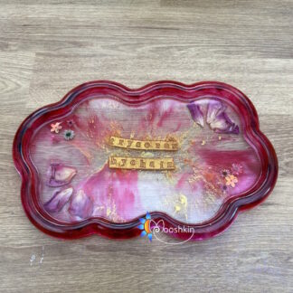 Handmade resin cloud tray, transparent pink with rose petals and gold splashes and the phrase 'trysorau bychain' (Welsh for 'tiny treasures')