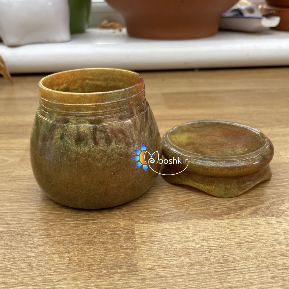 Handmade resin screw-top jar in gold with hints of red and green