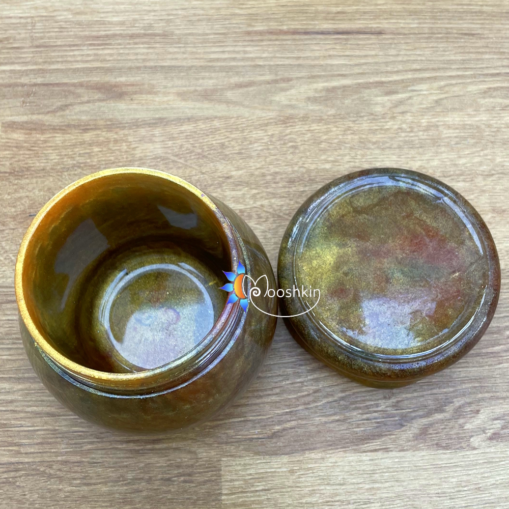 Handmade resin screw-top jar in gold with hints of red and green